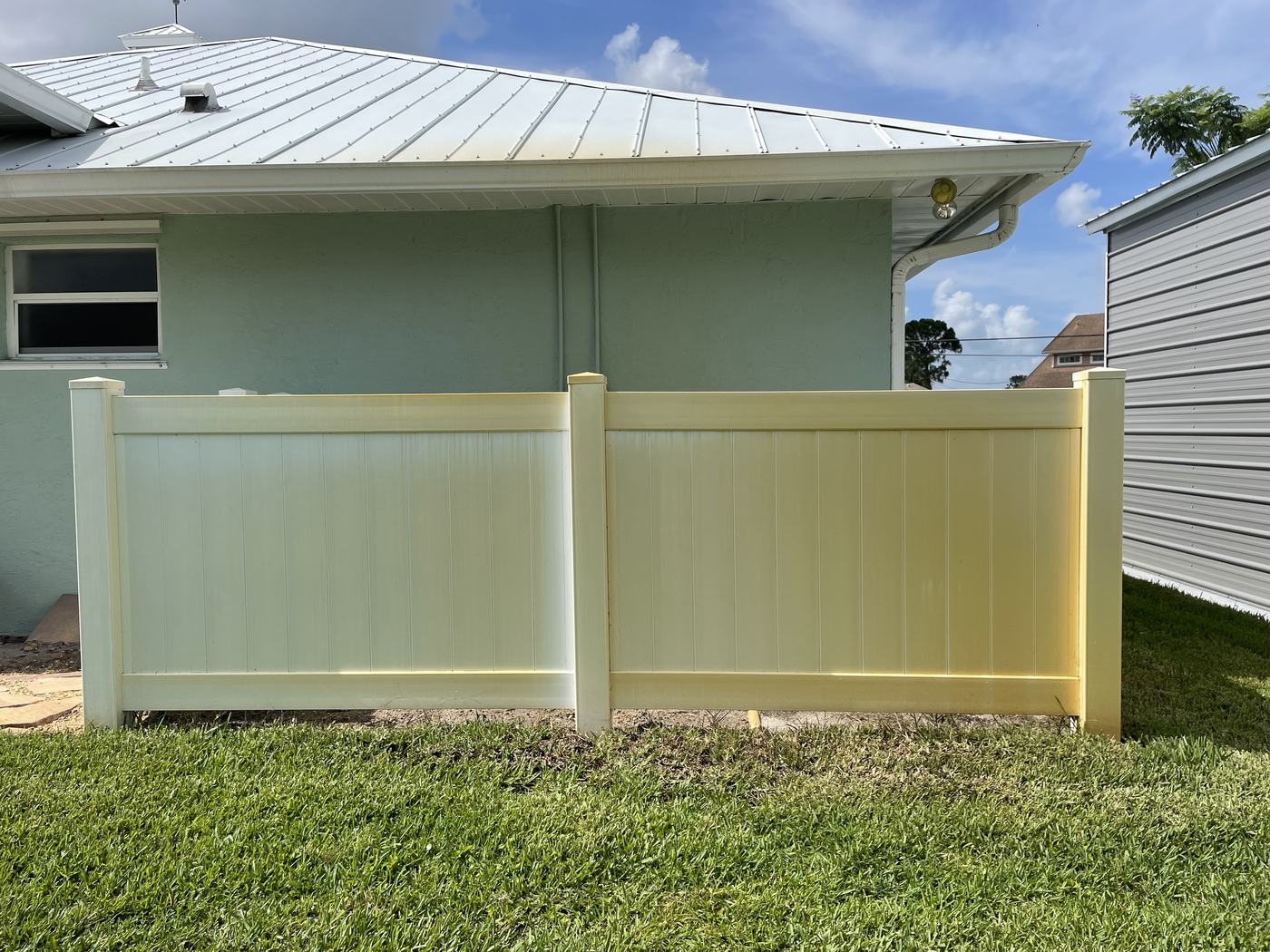 Vinyl fence before pressure washing — yellowed and stained